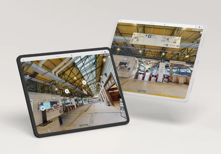 Two tablets showing SIM-ON 3D walkthroughs of Mojiko Station: the platform under a steel roof with asset icons, and the concourse with ticket gates and signs