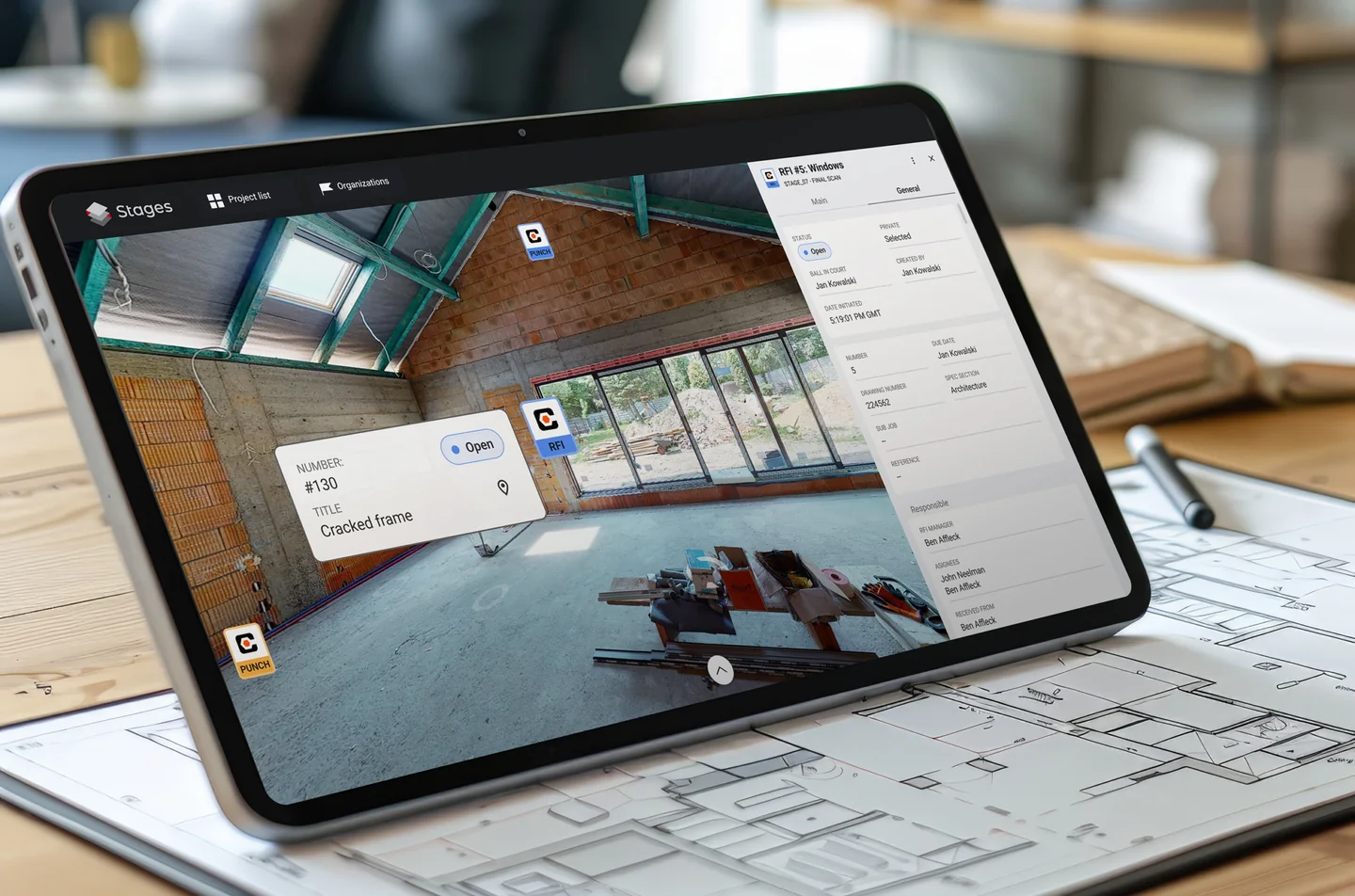 Tablet on a desk with drawings, showing STAGES with a Matterport scan of a site under construction, Procore Punch and RFI markers and an RFI #5: Windows details panel