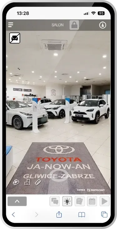 Phone screen showing the SIM-ON 3D tour of the Toyota showroom, with cars on display and a floor mat reading Toyota Ja-Now-An Gliwice-Zabrze