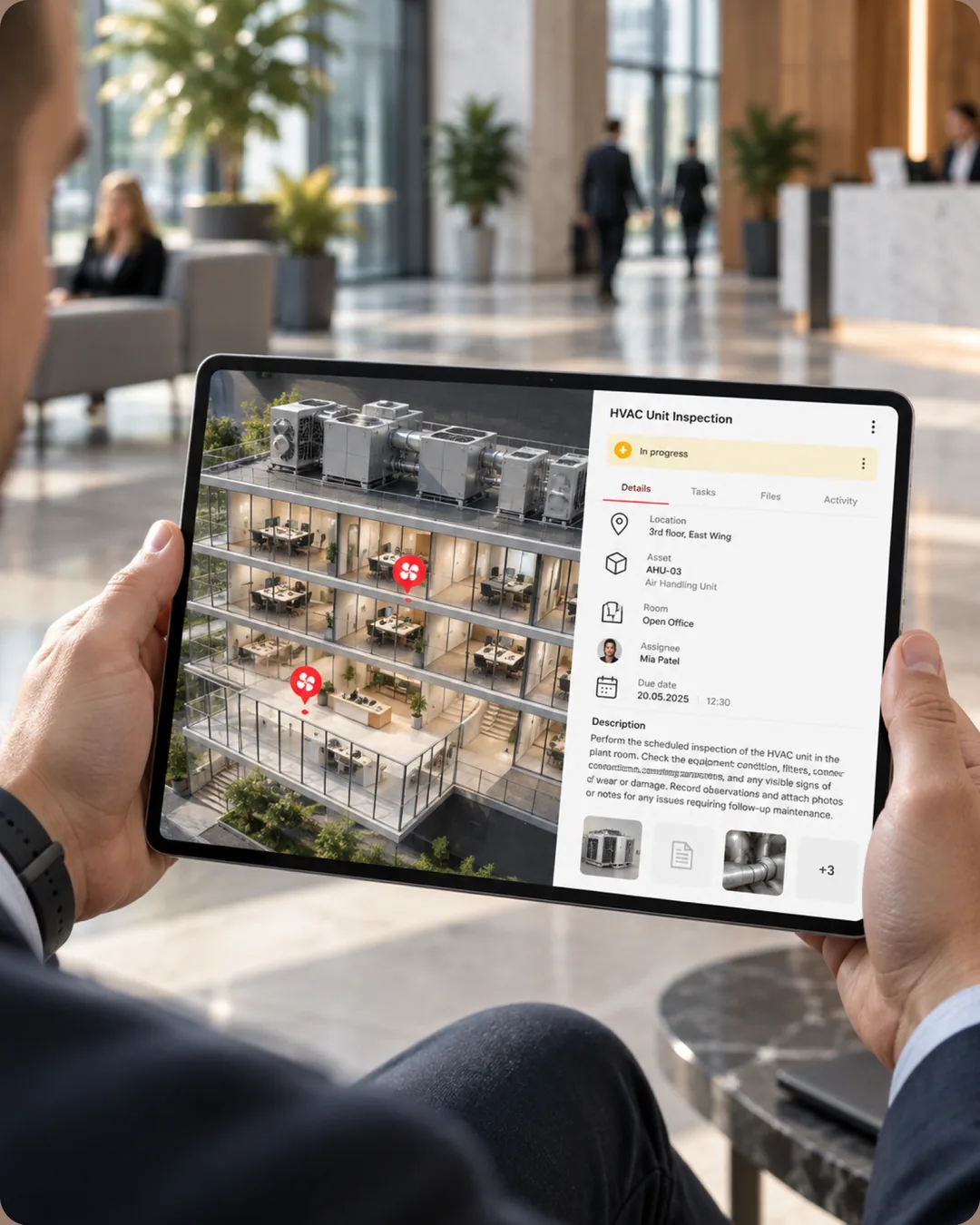 Hands holding a tablet in a lobby showing a building cutaway and an HVAC unit inspection task for air handling unit AHU-03